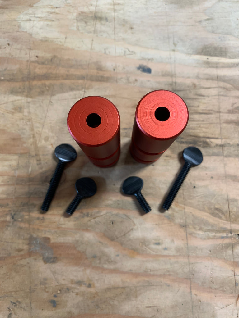 Set of Red Squjig 3" framing jigs, stood up on end. The ends have circle machining marks.